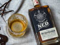 A glass and bottle of Ned Australian Whisky