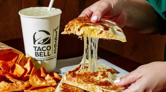 A person holds food from Taco Bell