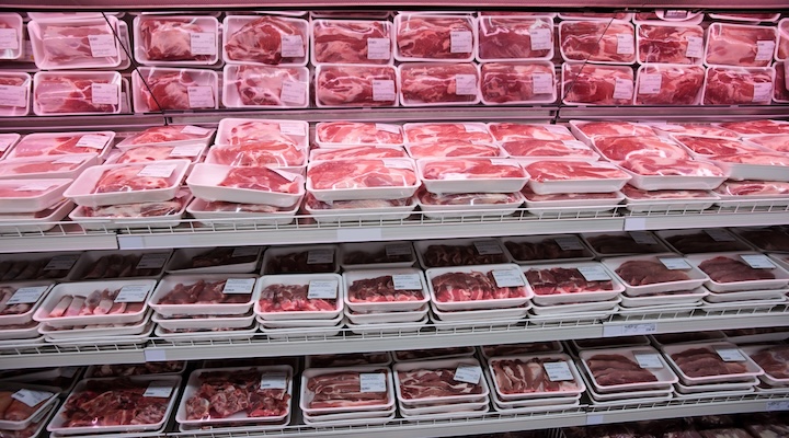 Fully loaded shelves with meat in a large supermarket