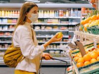 Women in grocery store selecting produce.