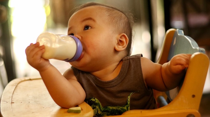 baby in chair drinking milk