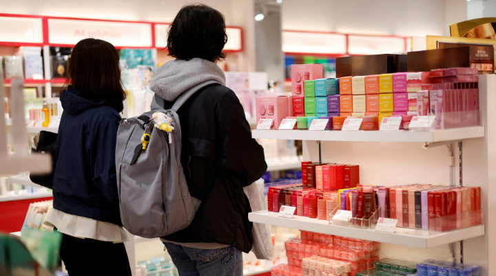 Shoppers browse cosmetics display.