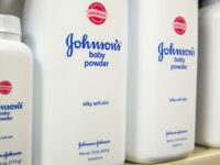 Bottles of Johnson & Johnson baby powder line a drugstore shelf