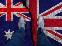 Business man stands on cracked flag of UK and Australia.