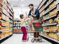 Young man and daughter are shopping in grocery store.